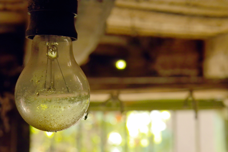 Нощем оплютата от мухи гола крушка осветява в жълто тайните на мазето